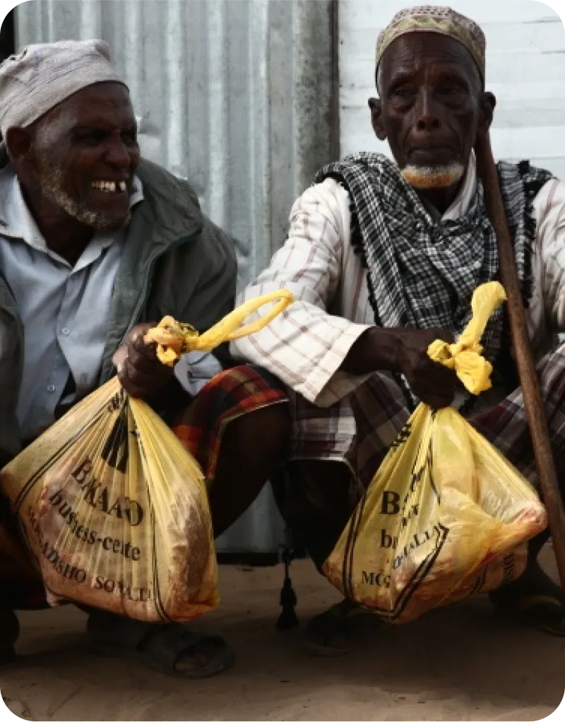 hommes recevant la viande partagée du sacrifice d'Aïd al-Adha par l'ONG LIFE