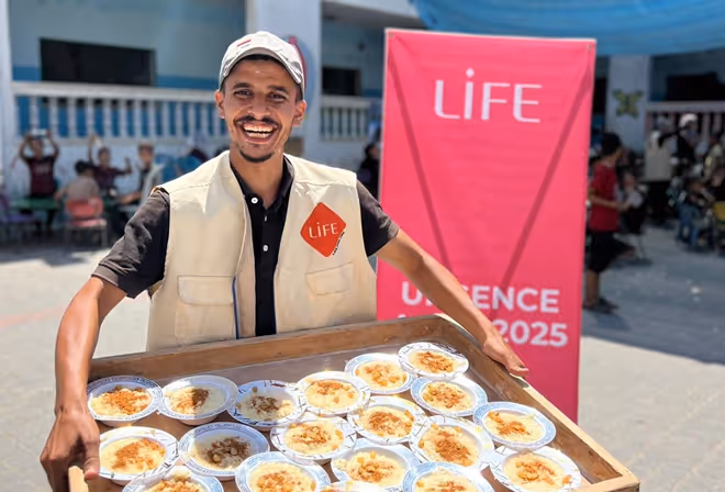 Distribution de repas chauds par un bénévole de l'ONG LIFE à Gaza. Association don palestine. Soutien Gaza.