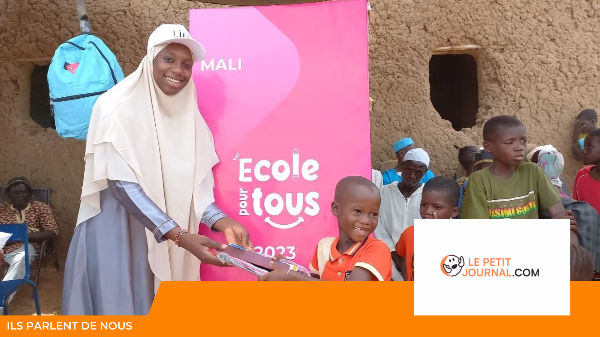 Jeune femme casquette LIFE remettant un cahier à un garçon souriant devant une affiche « École pour tous » Mali 2023