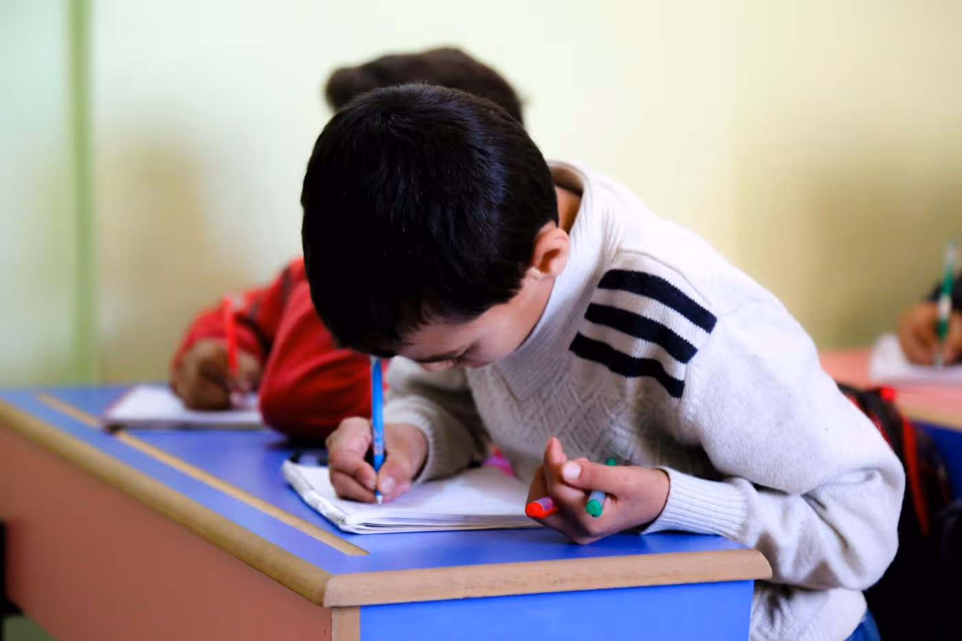 Un enfant écrit, soutien à la scolarité à Gaza