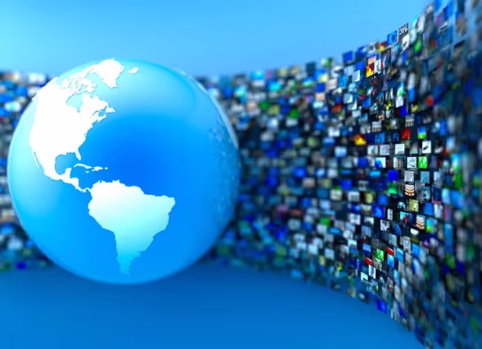 Globe terrestre bleu centré sur les Amériques, devant un mur incurvé de nombreux écrans d'images floues