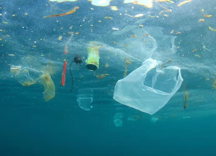Sacs plastique, bouteille et autres déchets flottant sous la surface de l'eau bleue de la mer