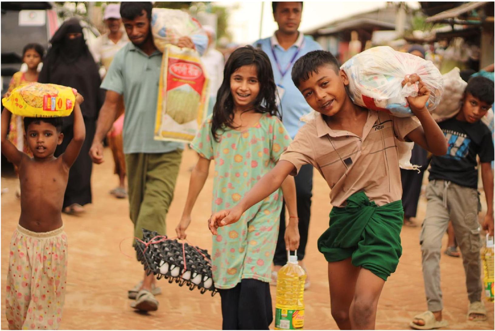 Des enfants rapportent des sacs de riz, des œufs et de l'huile après une distribution alimentaire